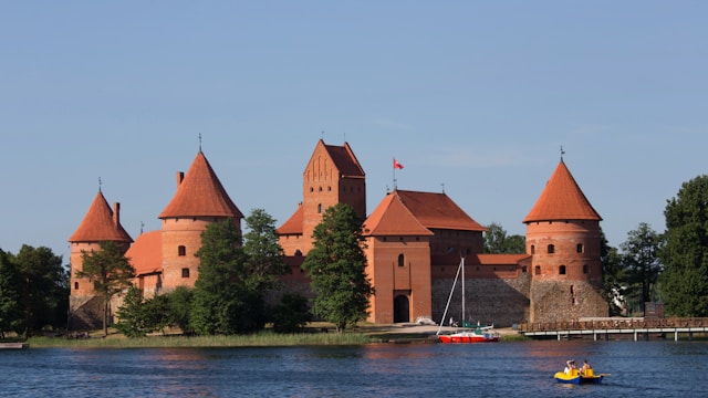 Takkai, castle made of red brick and red terracotta roof fronted by a lake.